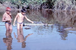 Figura 28- Crianças índias Uaura observando cestas de pequi que são estocadas submersas nas águas do lago próximas à aldeia, e, cujo fruto é consumido de acordo com a necessidade individual.