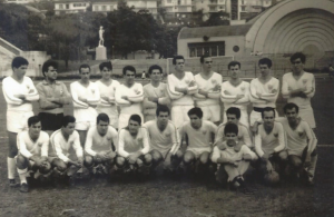 Figura 28: Equipe de futebol da EPM na minha primeira Pauli-Med (empate 2x2) em 1965, no estádio do Pacaembu. Ao fundo ainda pode ser vista a tradicional concha acústica que posteriormente foi demolida para a construção do tobogã. Estou agachado bem ao centro do grupo.